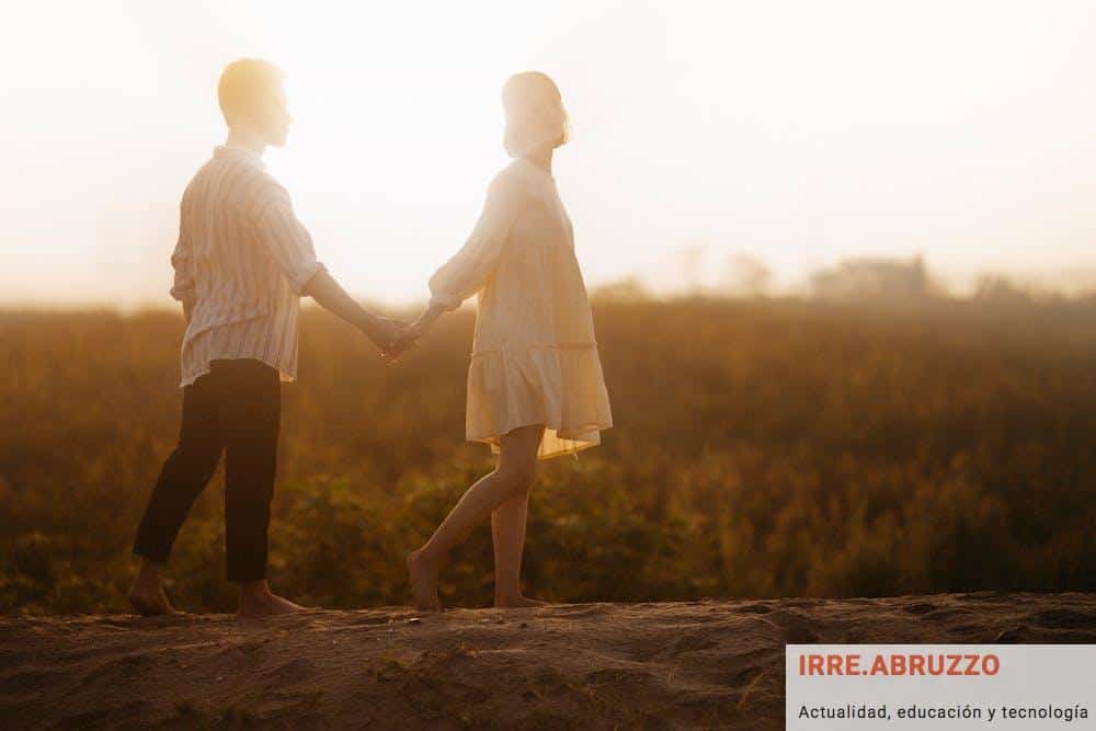 Couple Holding Hands on Sand Field